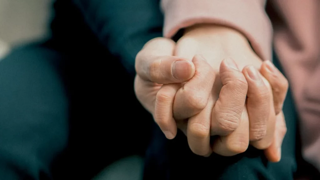 Two people's hands clasped together.