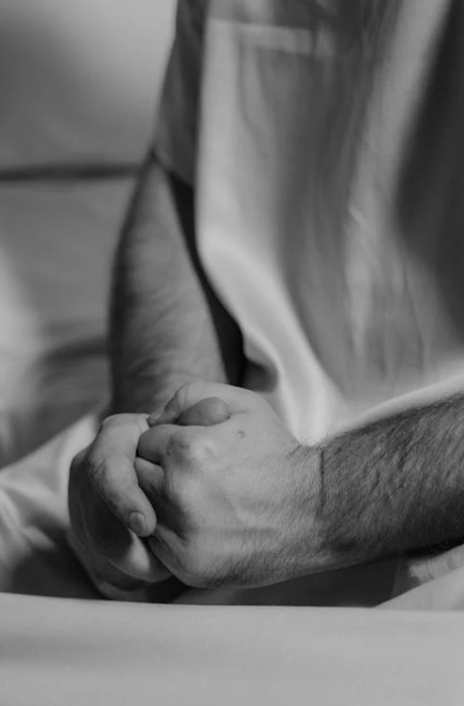 A person holding their hands together in fists.