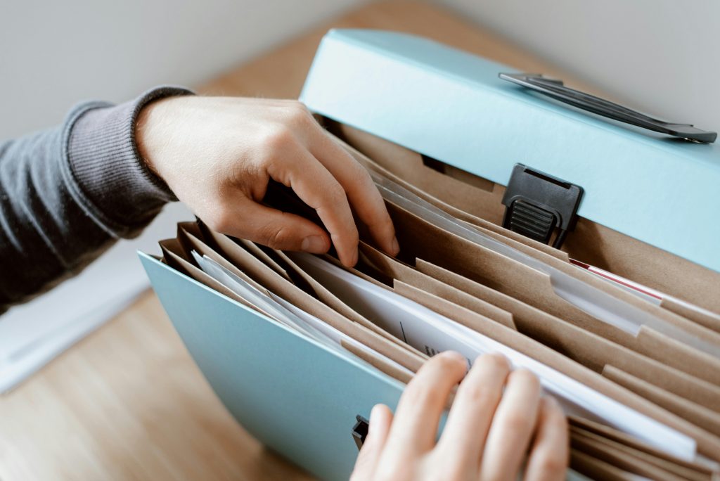 A person looking through a portable filing system for paperwork
