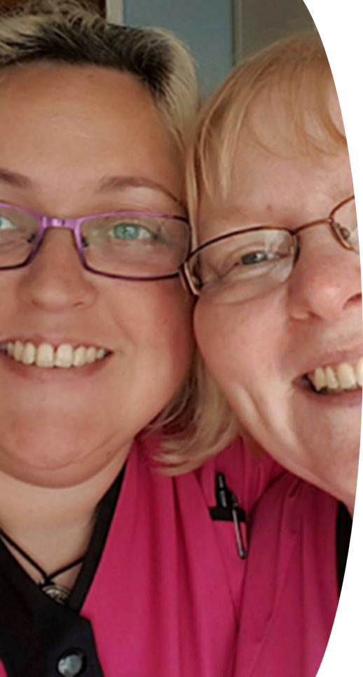 Two carers smiling at the camera in Teign Angels uniforms